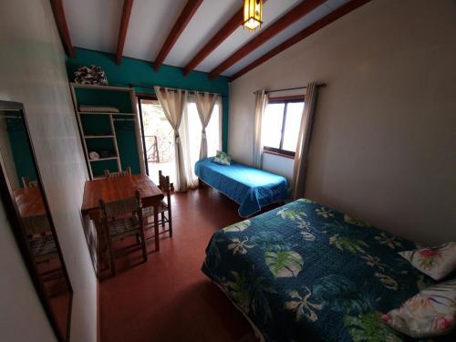 a bedroom with a bed and a table in a room at Hostal Vieroto in Hanga Roa