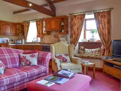 a living room with a couch and chairs and a kitchen at Rambling Rose- Lwg in Ireby