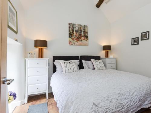 ein Schlafzimmer mit einem weißen Bett mit zwei Kissen in der Unterkunft Baileys Barn in Bonsall