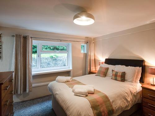 a bedroom with a large bed and a window at Frondeg in Aberaeron