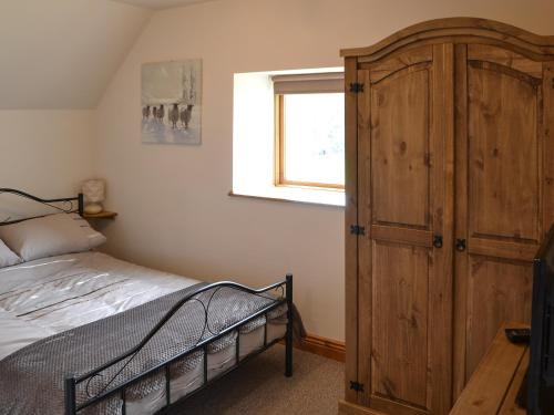 1 dormitorio con 1 cama y armario de madera en The Arches - Uk3223, en Linden
