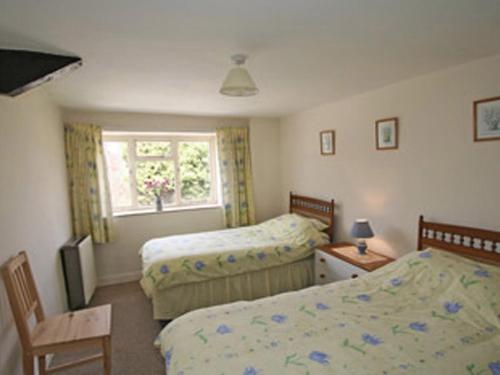 1 Schlafzimmer mit 2 Betten und einem Fenster in der Unterkunft Maxmills Cottage - E1852 in Banwell