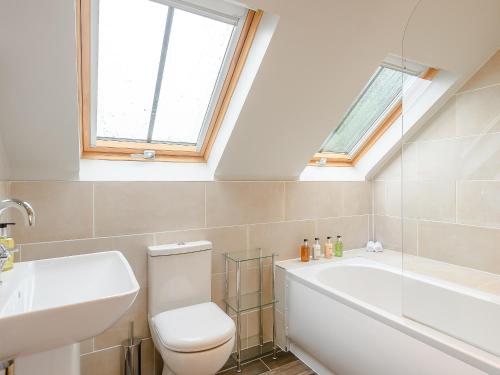 a bathroom with a toilet and a sink and a bath tub at The Granary in Hough on the Hill