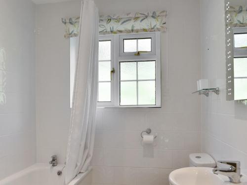 a white bathroom with a sink and a window at Valley View-e1866 in Powerstock