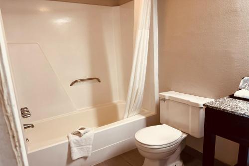 a bathroom with a toilet and a bath tub at Cambridge Inn in Oklahoma City