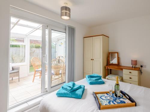 a bedroom with a bed and a balcony at Anchorage in Sutton on Sea