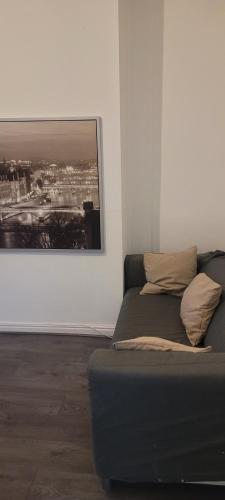 um sofá num quarto com uma fotografia na parede em 21 Decent Homes em Manchester