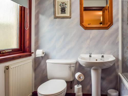 a bathroom with a toilet and a sink at Braeside House in Tobermory