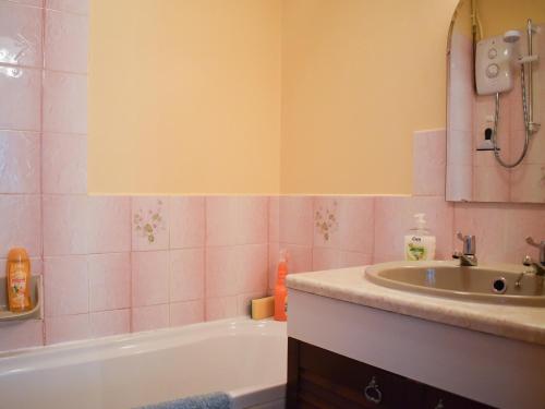 a bathroom with a sink and a bath tub at Mill Cottage, Marsh Mills in Aveton Gifford