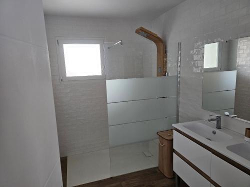 a white bathroom with a sink and a window at Villa in Passa