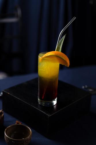 a drink with an orange slice on a black table at Bayon Modern Residence in Siem Reap