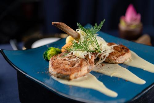 a blue plate of food with meat and broccoli at Bayon Modern Residence in Siem Reap