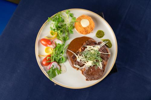 a plate of food with meat and vegetables on it at Bayon Modern Residence in Siem Reap