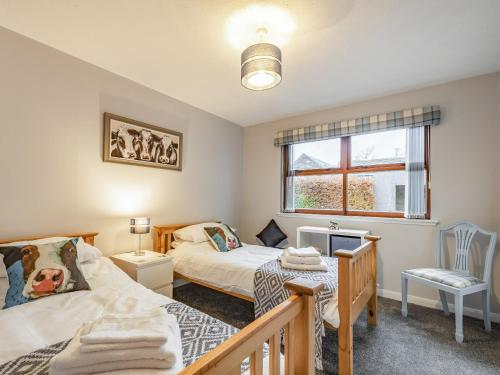 a bedroom with two beds and a window at Rowan Muir in Springside
