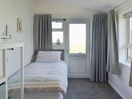 ein kleines Schlafzimmer mit einem Bett und einem Fenster in der Unterkunft Coles Retreat in Anderby