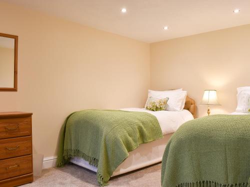 a bedroom with two beds and a dresser at Delamere House- The Snug in Scagglethorpe