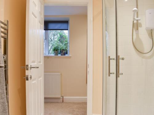 a bathroom with a shower and a glass shower door at Delamere House- The Snug in Scagglethorpe