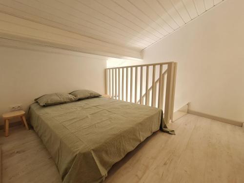 a bedroom with a bed and a wooden floor at Petit nid cosy entre vignes et forêt, tout inclus avec terrasse privative - FR-1-584-291 in Lagney