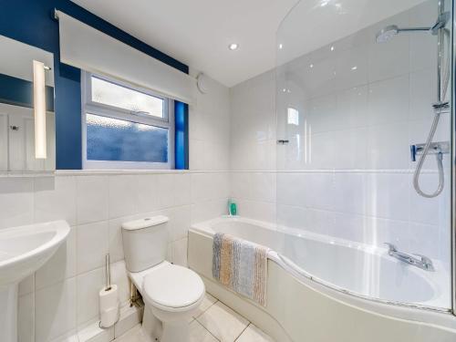 a bathroom with a toilet and a tub and a sink at Dovecoat Cottage in Embleton