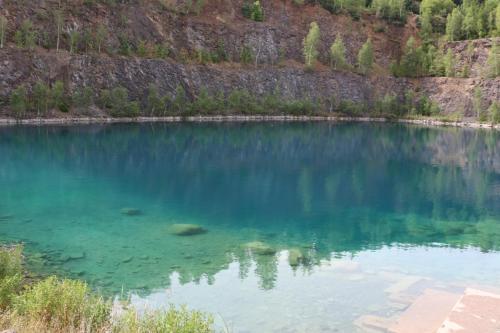 a large body of blue water with trees in the background at Ferienwohnung Brunow "In der Natur Zuhause" in Neundorf