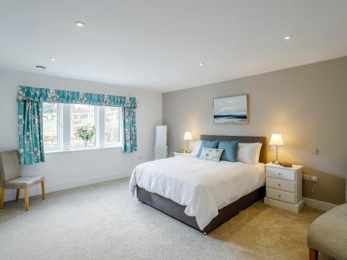 a bedroom with a large bed and a window at Cunliffe Cottage in Hathersage