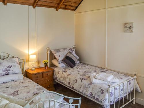 sypialnia z 2 łóżkami i drewnianym sufitem w obiekcie Sea Scape w mieście Bacton