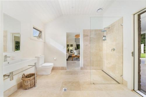 a bathroom with a shower and a toilet and a sink at Wembley House, Southern Highlands in Berrima