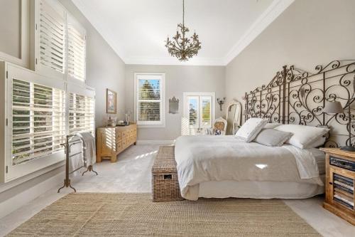 a bedroom with a large bed and a chandelier at Wembley House, Southern Highlands in Berrima