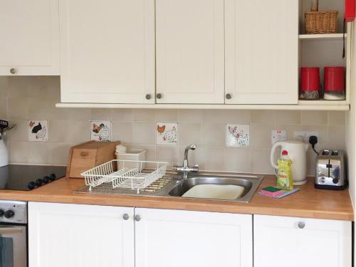 fregadero de cocina con barra de secado de platos en The Wee House en Muthill