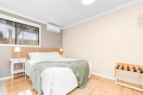 a white bedroom with a bed and a window at Central guest studio with secure parking! in Wagga Wagga