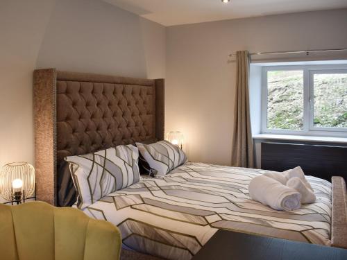 een slaapkamer met een groot bed met kussens en een raam bij Ivy House in Dockray