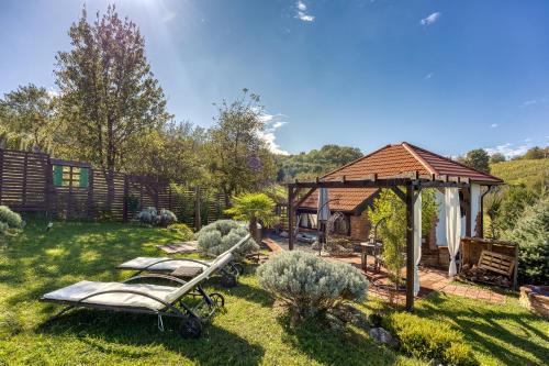 a garden with a gazebo and two chaises at Romantic Haven with Hot Tub - Happy Rentals in Beretinec