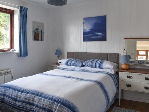 a bedroom with a bed with a blue and white blanket at Sea View - Uk30589 in Polperro
