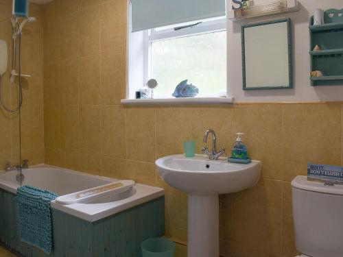 a bathroom with a sink and a tub and a toilet at Sea View - Uk30589 in Polperro