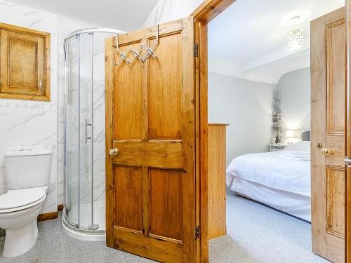 a bathroom with a toilet and a wooden door at The Old Vicarage in Stowe