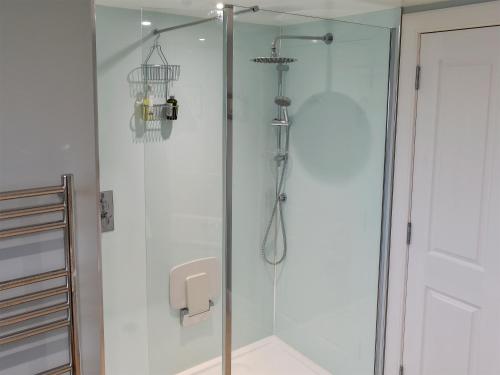 W łazience z przeszklonymi drzwiami znajduje się prysznic. w obiekcie The Annex At Fernyrig w mieście Birgham