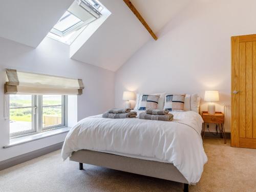 um quarto branco com uma cama e uma janela em The Hayloft - Uk34565 em Whitchurch
