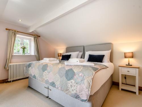 Un dormitorio con una cama grande y una ventana en Box Tree Cottage en Blakeney
