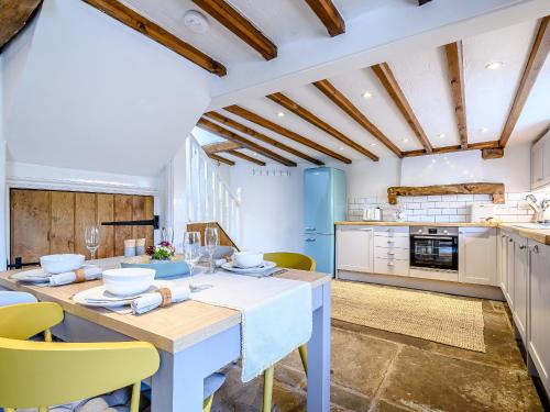 a kitchen with a table and chairs in a room at Box Tree Cottage in Blakeney