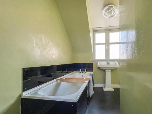 a bathroom with a bath tub and a sink at Fishermans Cottage in Gardenstown
