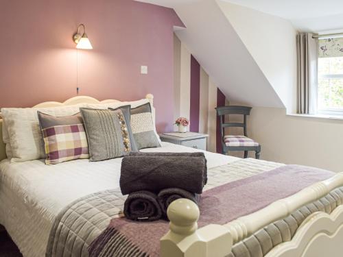 a bedroom with a large bed and a staircase at Pinch Cottage in Neyland