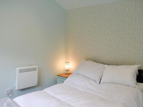 a bedroom with a white bed and a radiator at Shepherds Hut 3 At Laddingford - Uk32532 in Yalding