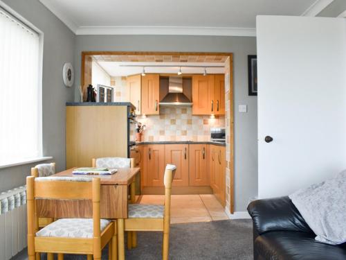 kuchnia i jadalnia ze stołem i krzesłami w obiekcie Dolphin Cottage w mieście Grange-over-Sands