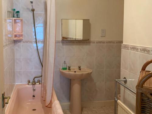 a bathroom with a shower and a sink and a tub at Primrose Cottage in Bowness-on-Windermere