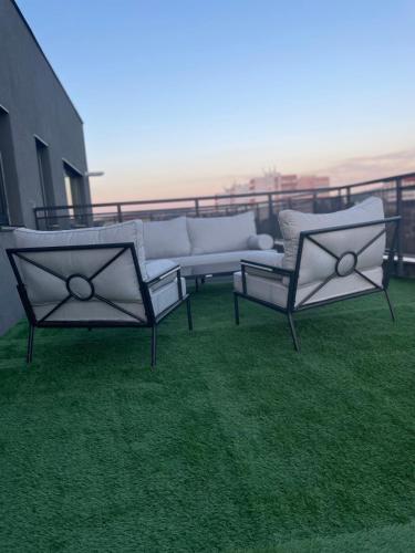 three chairs and a couch sitting on a balcony at Best View Terrace in Târgu-Mureş