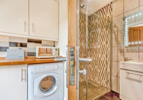 a washing machine in a kitchen with a shower at Gwynnant House in Rhyd Lewis