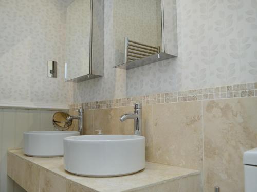 een badkamer met 2 wastafels en een spiegel bij The Cottage in Cheltenham