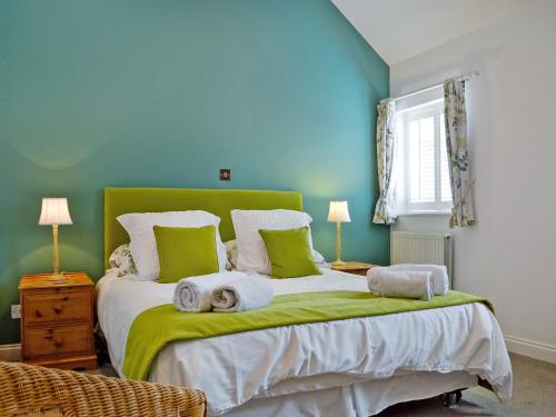 um quarto com uma cama grande e paredes verdes em The Cottage em Cheltenham