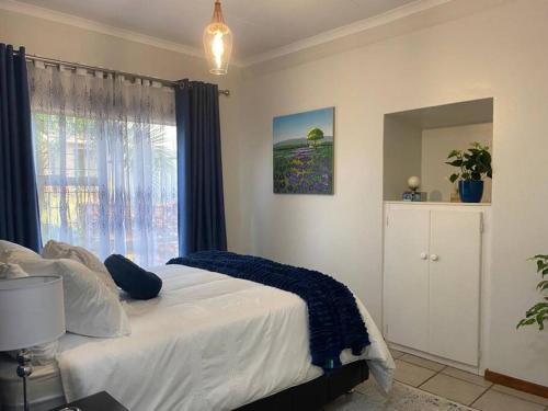 Un dormitorio con una cama grande y una ventana en CozyatCaley - Private Apartment en Centurion