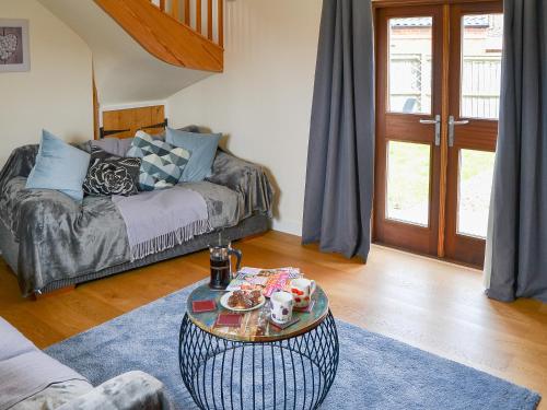 - un salon avec un canapé et une table basse dans l'établissement Stepping Stone Cottage, à Bacton